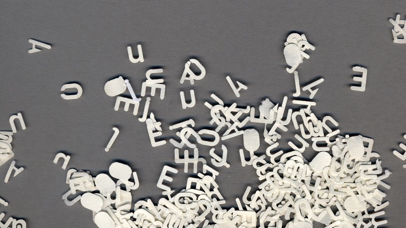 Image is a collection of white alphabet letters scattered across a grey background