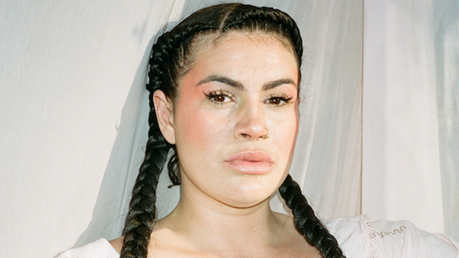 Image of Hannah Bronte wearing white top with hair in two plaits