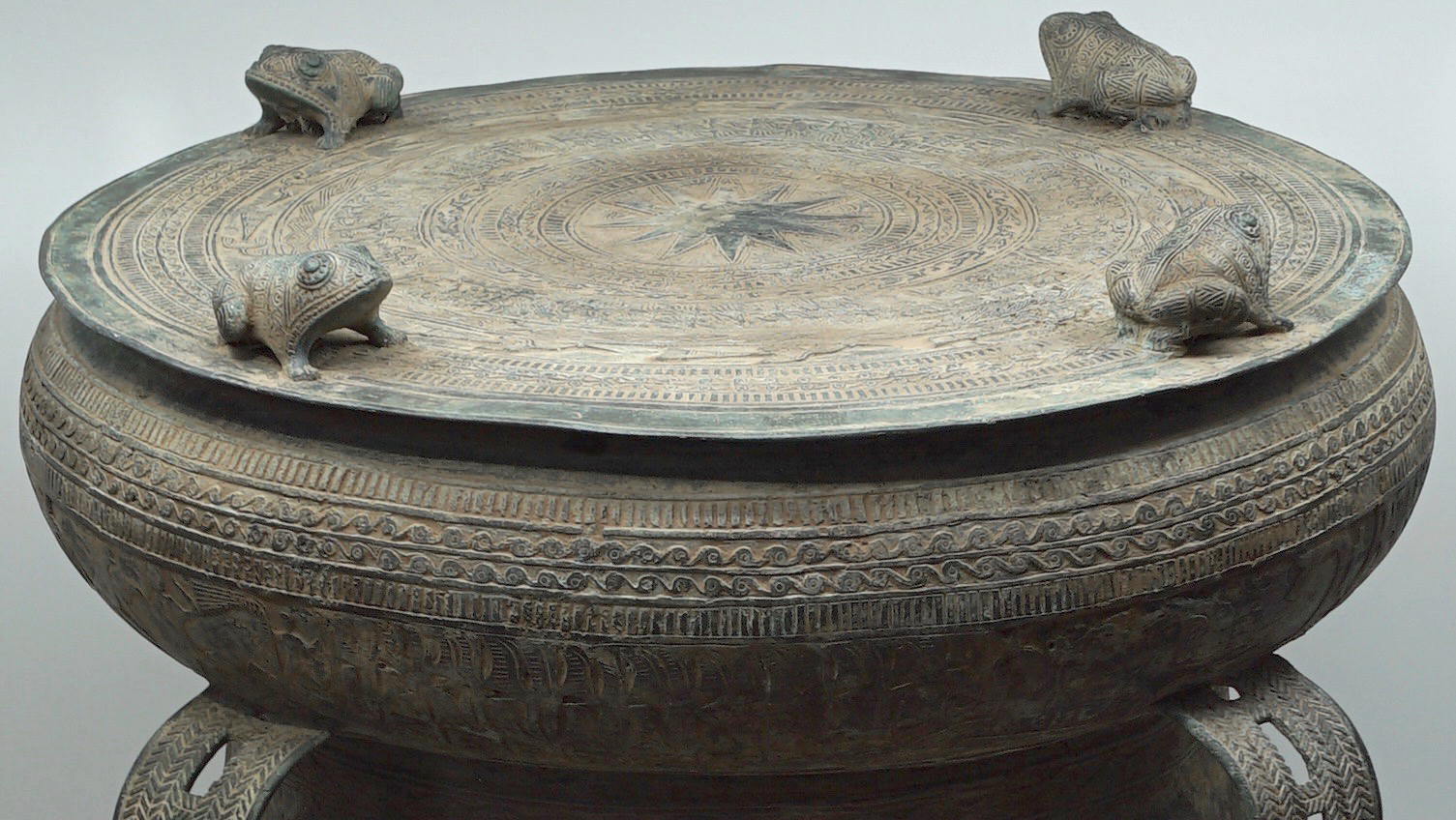 Resounding Research page full photo of ancient bronze drum with handles and decorative frogs image by James Nguyen