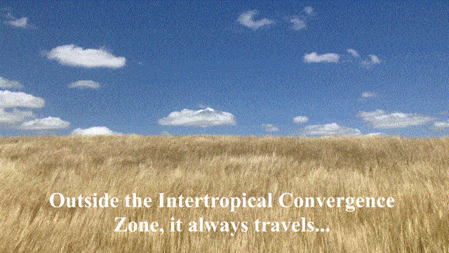 A horizon between a blue sky spotted with white fluffy clouds, and a sea of brown, weedy grass swaying towards the horizon in the wind. White text appears on top of the gif that says ‘Outside the Intertropical Convergence Zone, it always travels...’