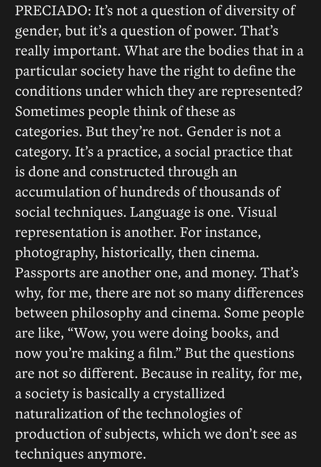 Screenshot of white text on a black background: PRECIADO: It's not a question of diversity of gender, but it's a question of power. That's really important. What are the bodies that in a particular society have the right to define the conditions under which they are represented? Sometimes people think of these as categories. But they're not. Gender is not a category. It's a practice, a social practice that is done and constructed through an accumulation of hundreds of thousands of social techniques. Language is one. Visual representation is another. For instance, photography, historically, then cinema. Passports are another one, and money. That's why, for me, there are not so many differences between philosophy and cinema. Some people are like, "Wow, you were doing books, and now you're making a film.” But the questions are not so different. because in reality, for me, a society is basically a crystallized naturalization of the technologies of production of subjects, which we don't see as techniques anymore.